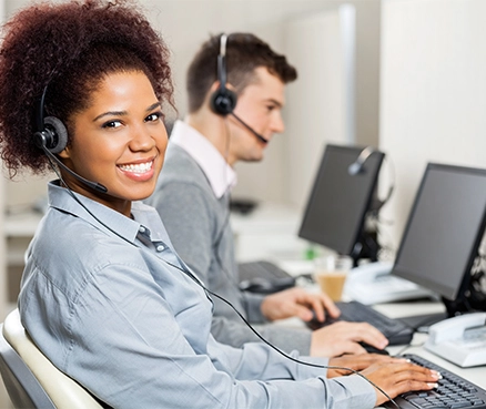 employees sitting in front of computers wearing headsets