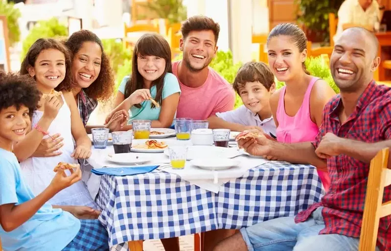 Two families eating a meal on their vacation at a five bedroom Pigeon Forge cabin