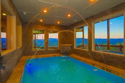 indoor pool with windows looking out at mountain views at Wonderland Lodge cabin