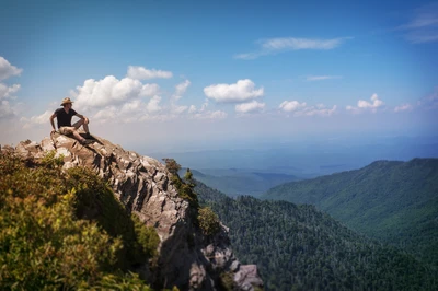 hiker sitting on rock admiring mountain view from Charlies Bunion Trail